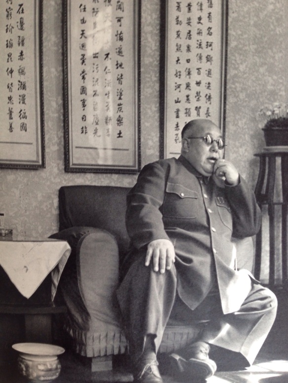 General Ma Hung-kwei came to Nanking, Kuomintang capital, every year to meet Marshal Chiang K'ai-shek.  The first syllable of his name, Ma, means horse, a very common name designation among Chinese Moslems.  Behind him, carefully written, are some old ryhmed precepts: "A good general should occupy a splendid place in history.  He should be praised during a hundred generations.  He should be full of care for his men and also for his people."  General Ma was the big war lord of Northwest China.  His secretaries were dressed as hospital nurses.  He adored ice cream and always had bucketfuls handy, and offered to his guests.  Shortly after this photograph was taken, General Ma was abandoned by his troops.