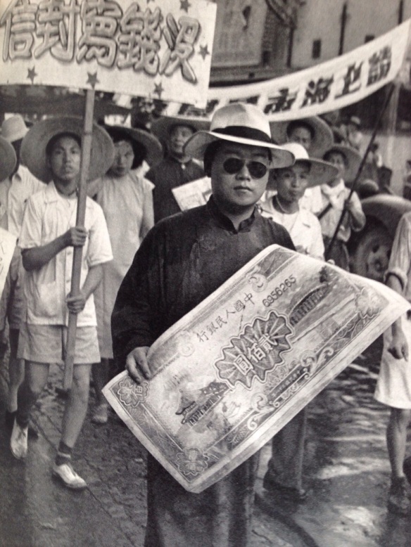 After the taking of Shanghai there were so many parades and meetings that they almost overlapped.  Here is the celebration of the official entry of the army into Shanghai on August 1, 1949.  A Union delegate holds an enlarged copy of the new paper money.  The processions were used to publicize the problems of the hour.  The ceremony had been planned for July 5 but in the face of the Kuomintang threat to bomb it from the air, it was postponed to the 6th.